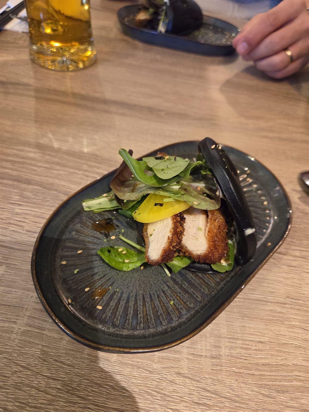 Bau bun noir garni de poulet croustillant et de salade